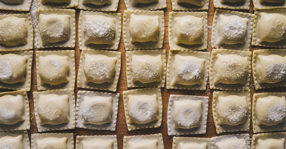 Raw traditional Italian ravioli with flour,Basil,Egg,And salt on a wooden board