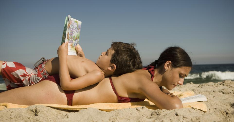 Moeder en zoon lezen op strand