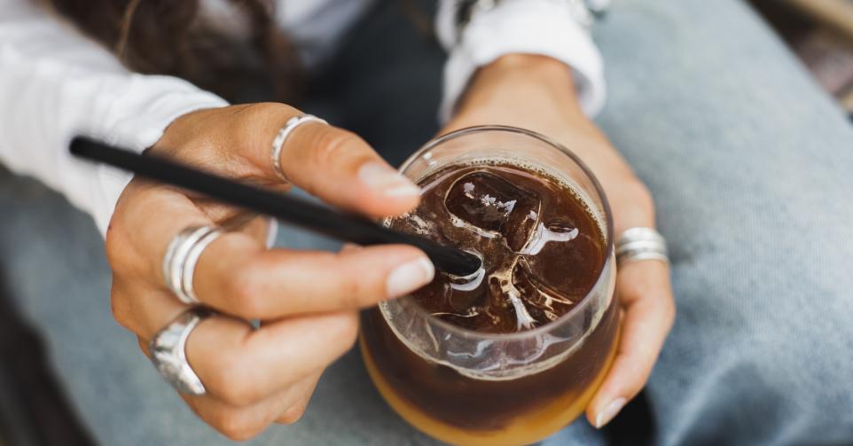 Cold summer drink. Espresso based beverage with fresh orange juice. CIty life, young people lifestyle. Refreshing drink. Copy space background with unrecognizable person.