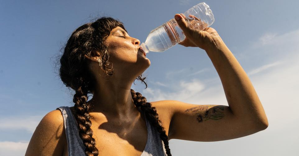 Mid adult woman drinking water outdoors