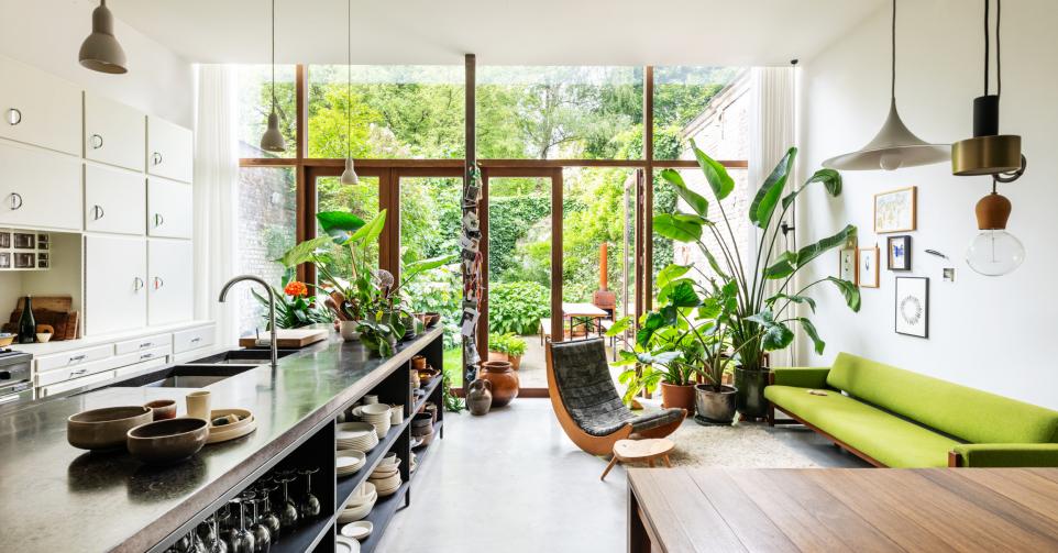 De volumineuze uitbouw van de rijwoning ontwierp Karolien zelf. Zeven meter brede raampartijen geven uit op de grote groene tuin.