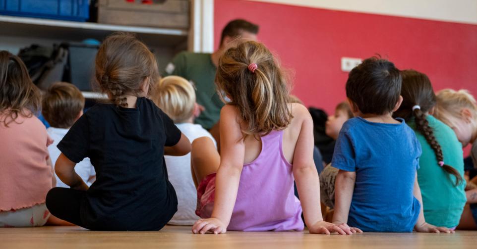 Man speelt met kleuters in kinderopvanglocatie in Vlaanderen.