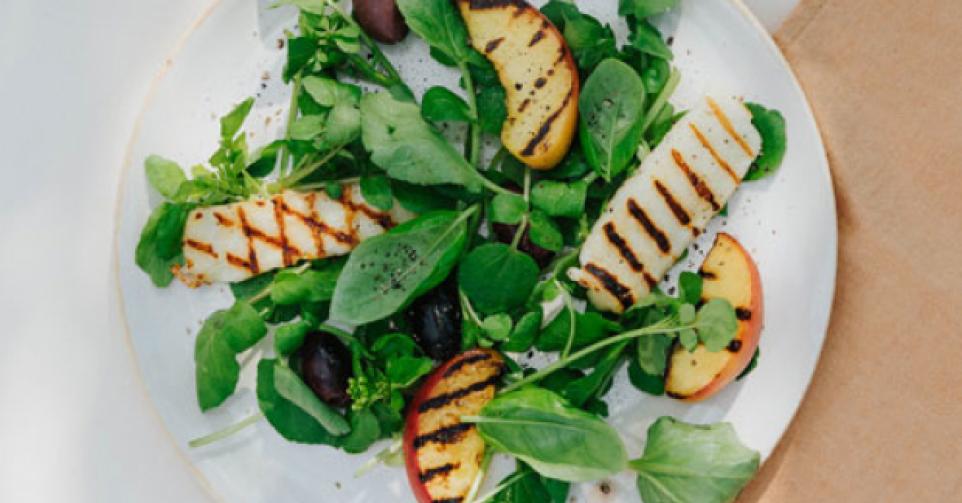 Salade van gegrilde perzik, basilicum, halloumi en zwarte olijven