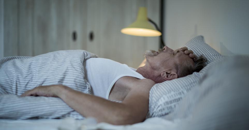 Homme âgé malade (grippe) couché dans son lit